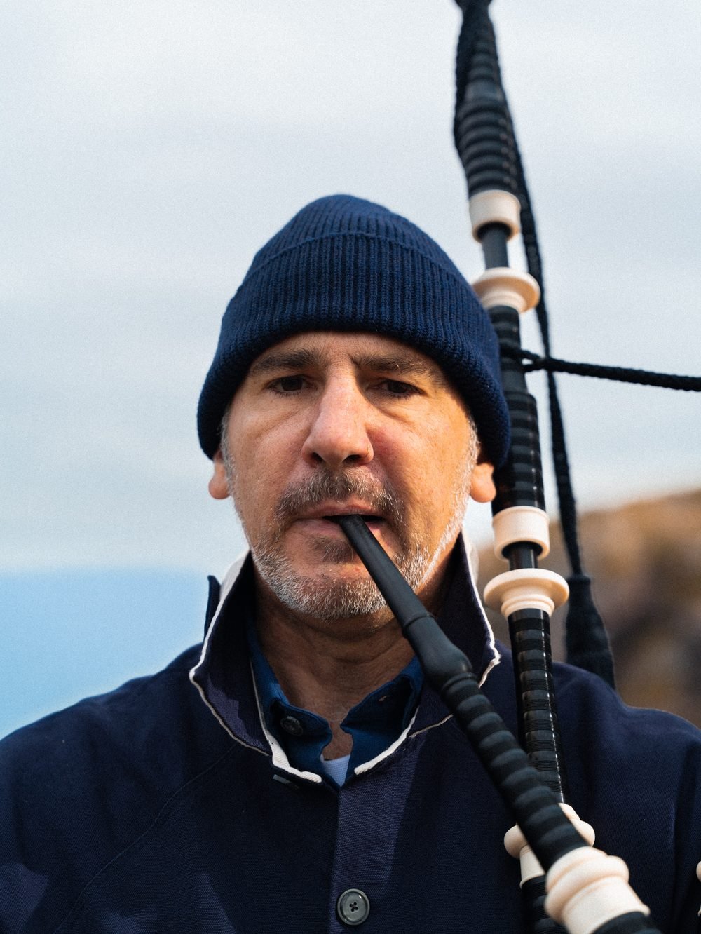 Portrait rapproché du sonneur en train de jouer, bonnet bleu marine.