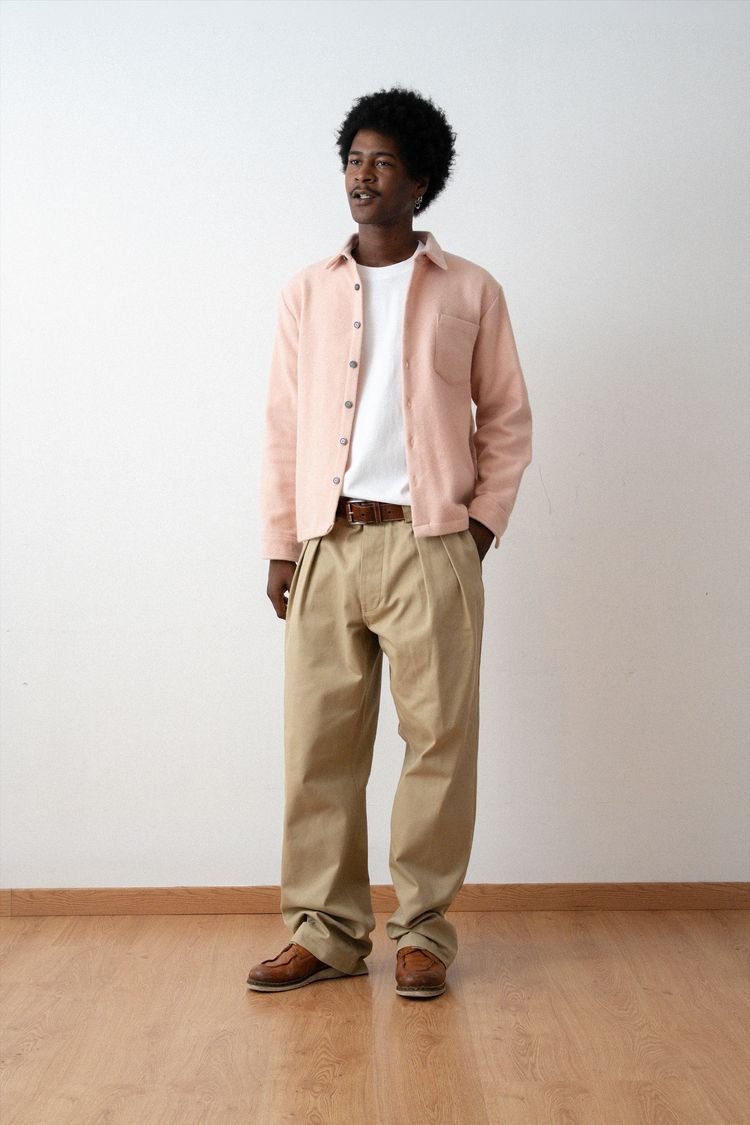 Surchemise épurée rose pâle et pantalon beige, en pied.