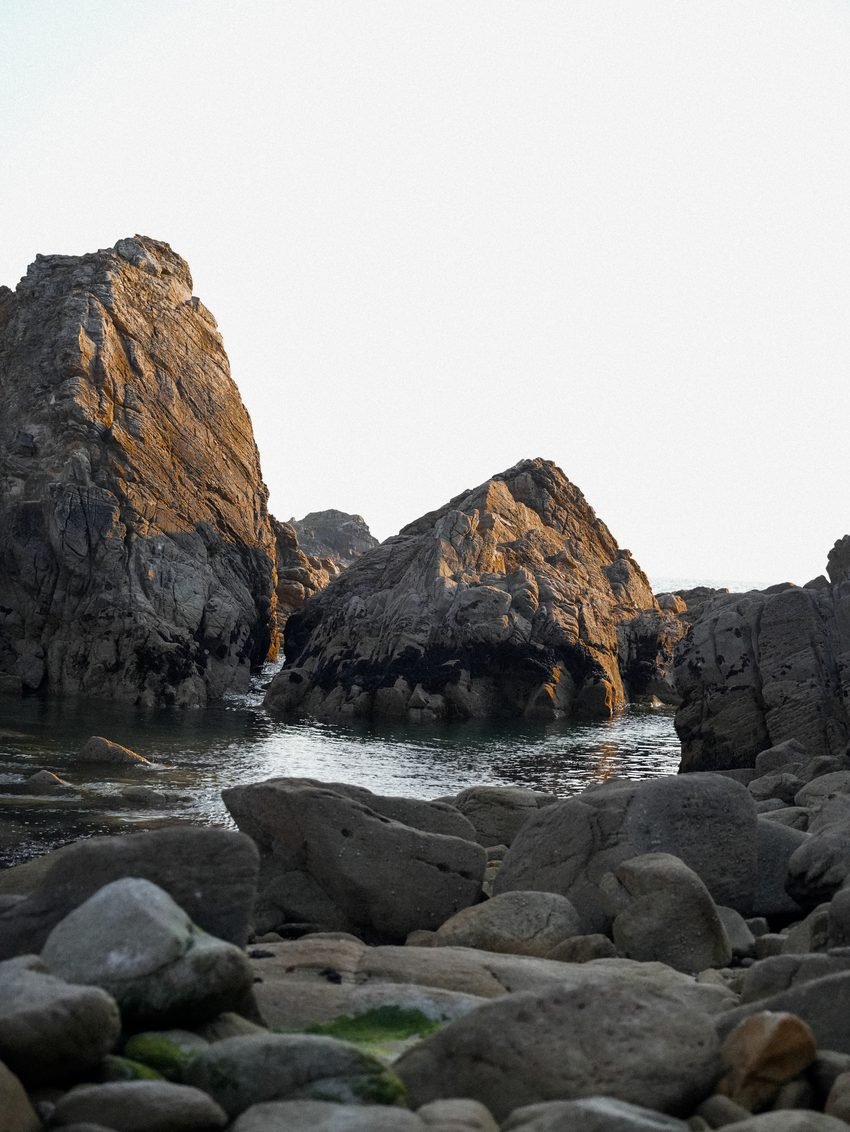Rochers et bassin d'eau de mer au crépuscule.
